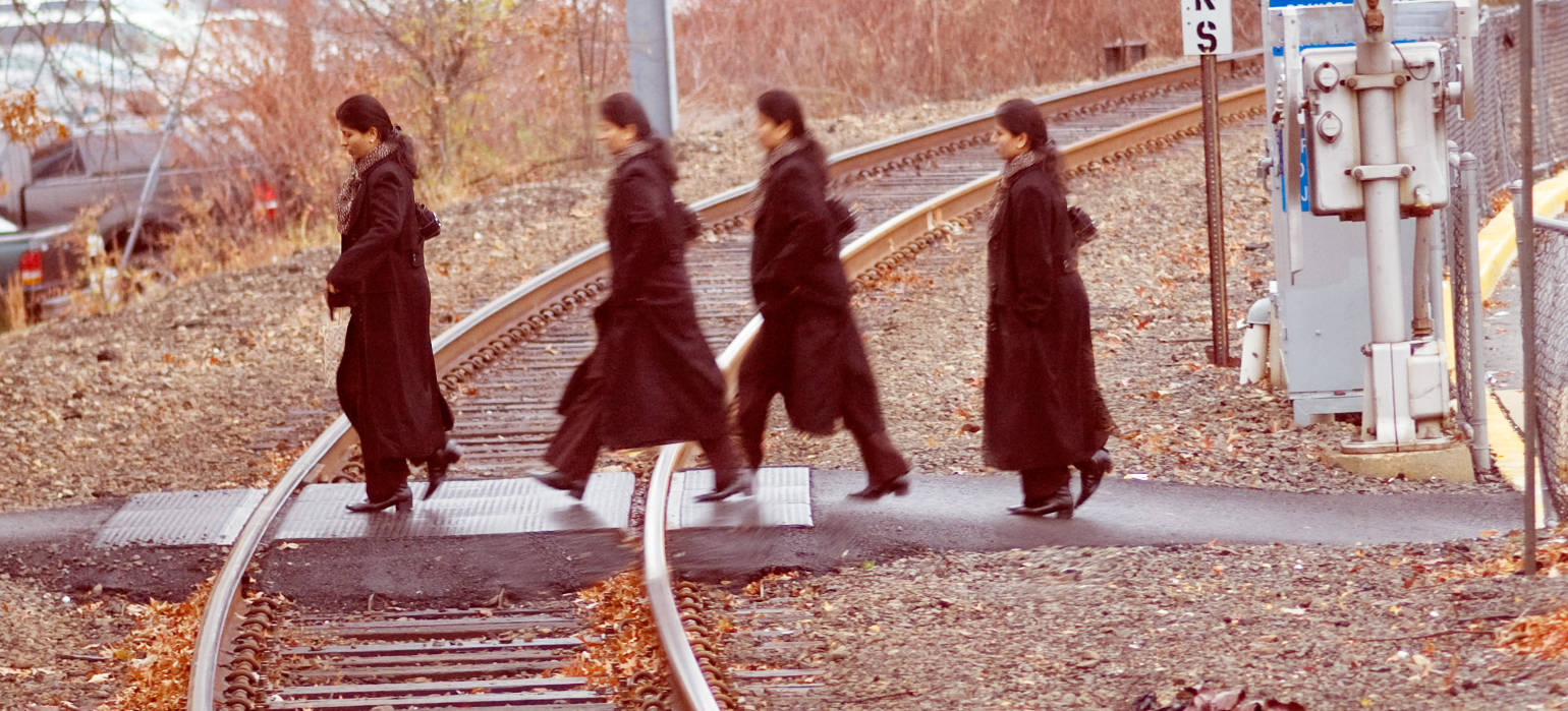 woman walking across train tracks