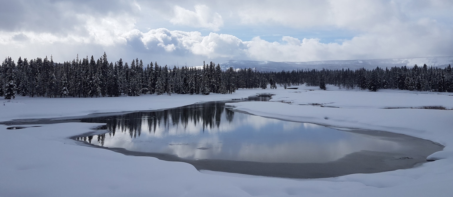 Winter view of snow, river, trees, mountains, clouds at Flagg Ranch, Rockefeller Parkway, Wyoming