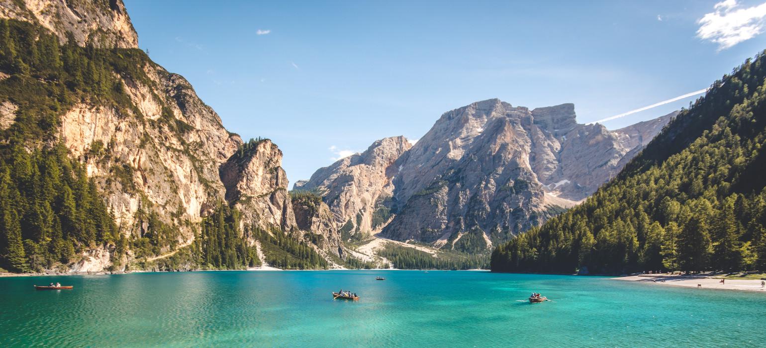 three brown wooden boat on blue lake water taken at daytime