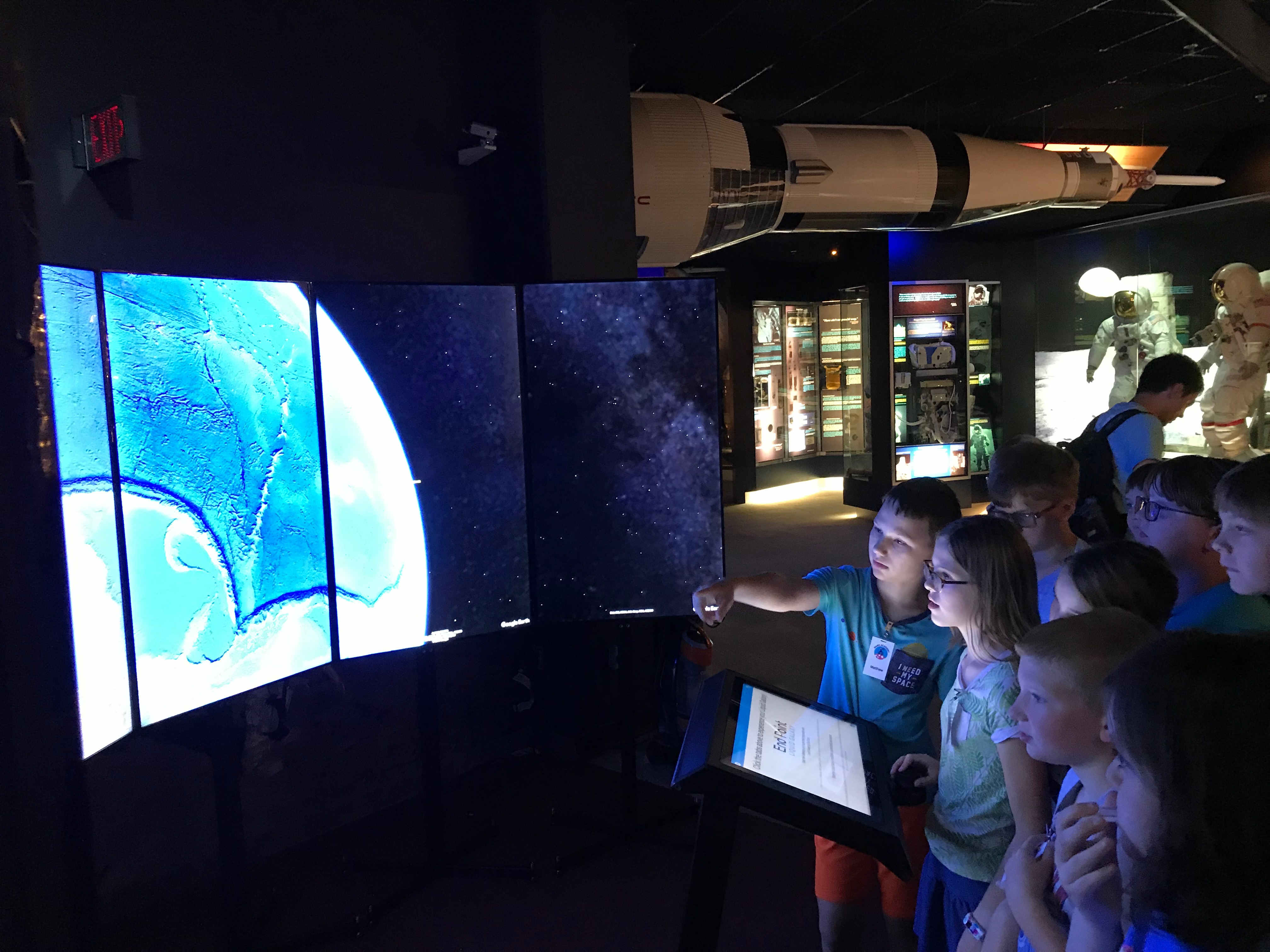 An excited kid points at the Liquid Galaxy