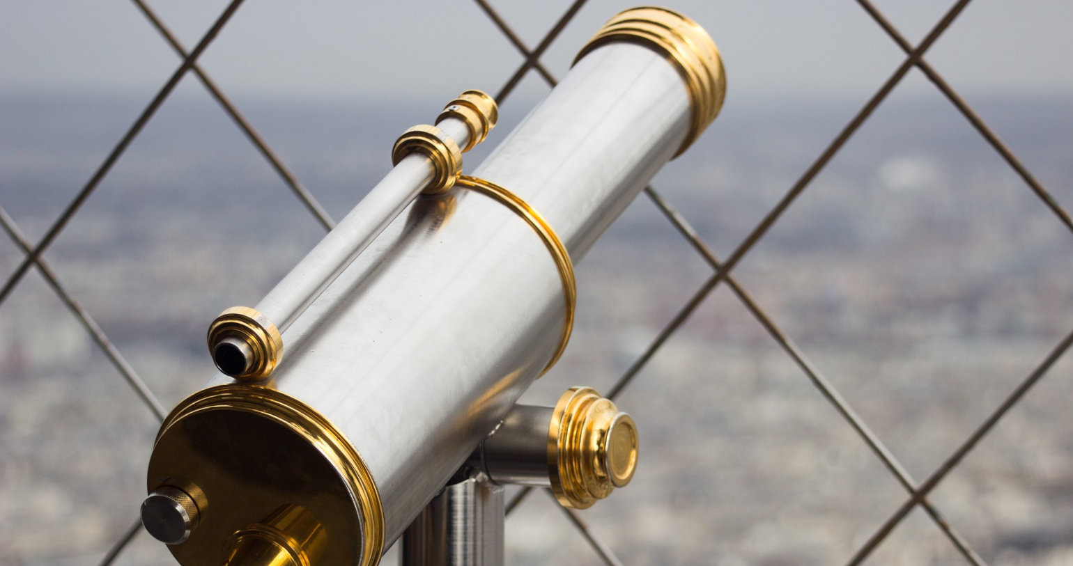 Mounted telescope monocular pointing through a wire fence