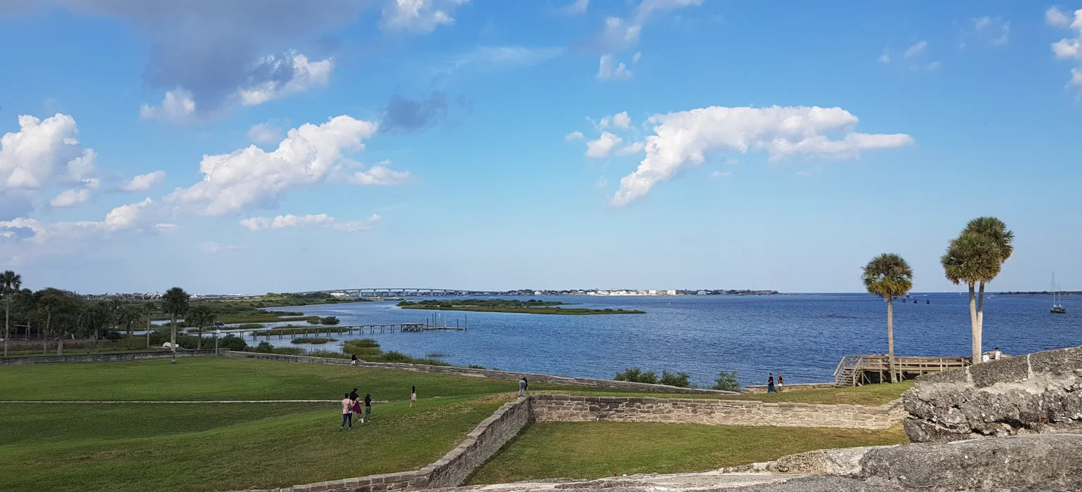 scene of seashore, palm trees, bridges, old stone walls, grass