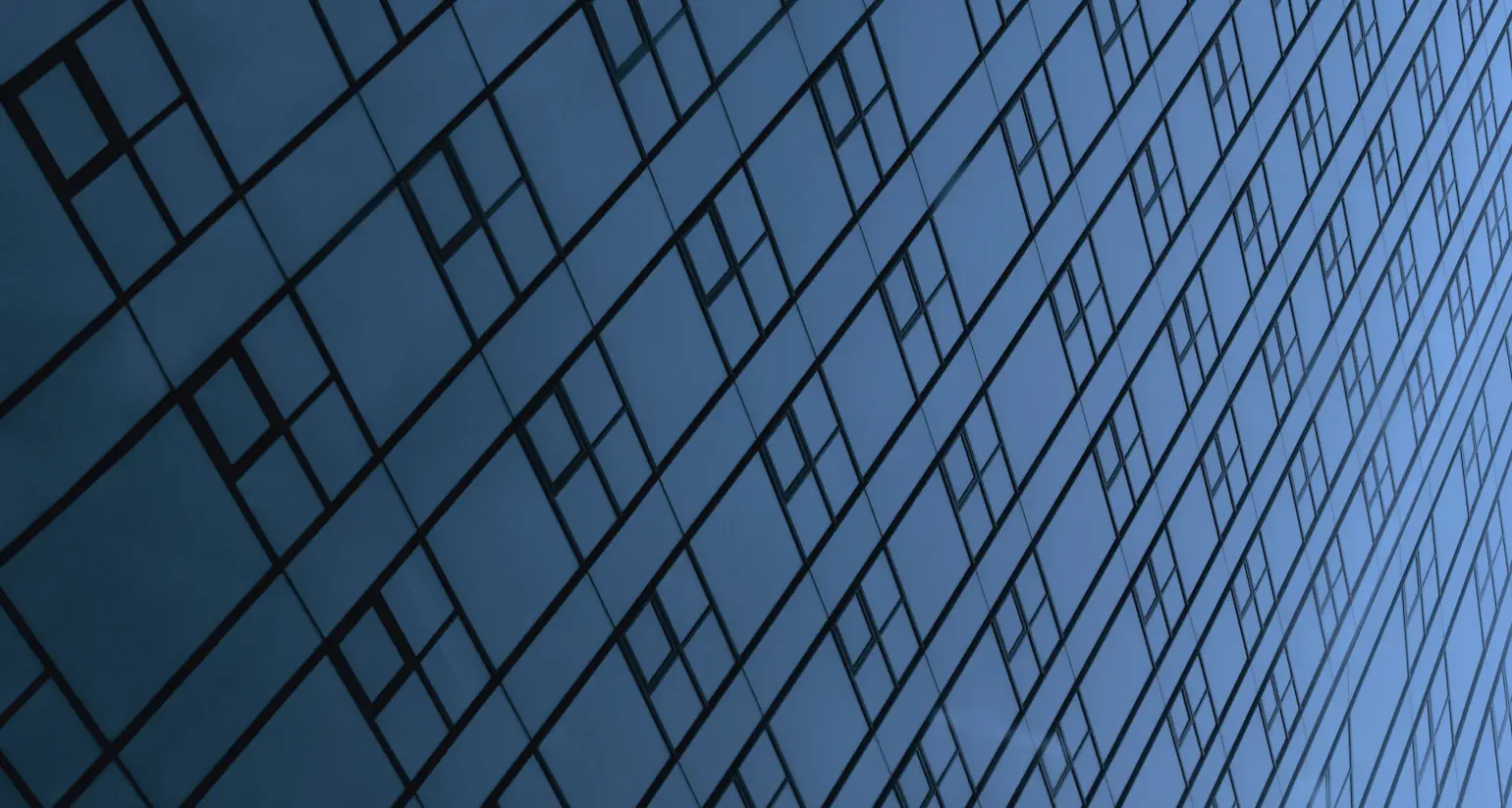 Photo of dark blue glass with lines and right angles, perhaps windows of a modern skyscraper