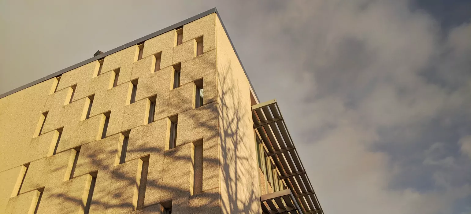 A concrete building with rectangular windows at sunset