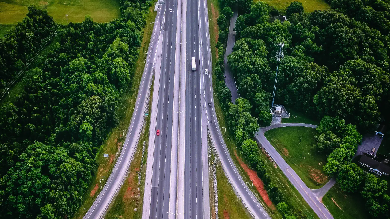 Divided interstate highway in lush green trees and fields