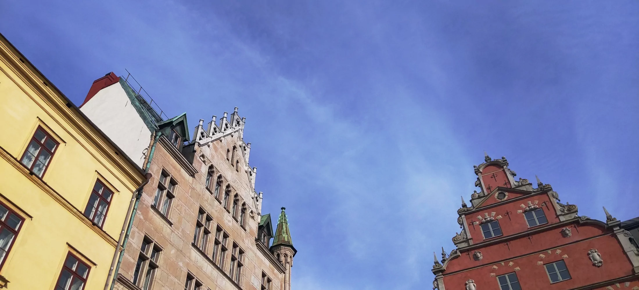 Several buildings with a lightly cloudy blue sky