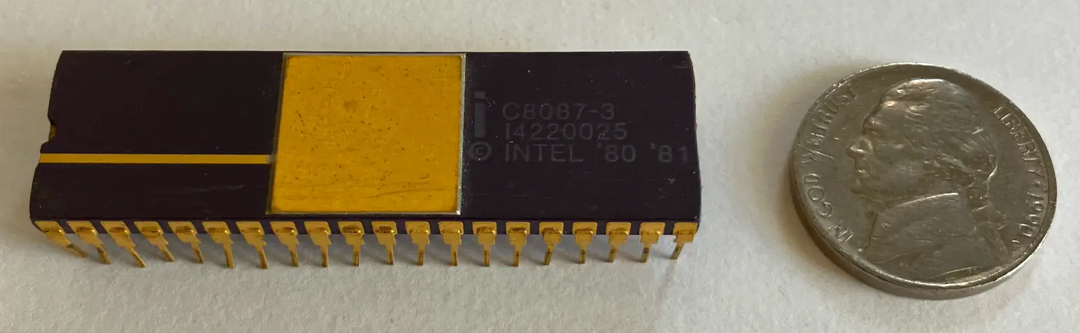 Intel 8087 chip imprinted with part numbers and “© Intel ‘80 ‘81” alongside a U.S. 5¢ piece (nickel) for scale