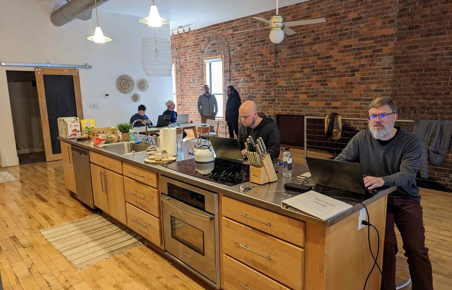 Casablanca, kitchen area. Food is laid out on the end of the counter, while the other end is taken by two laptops occupied by End Pointers.