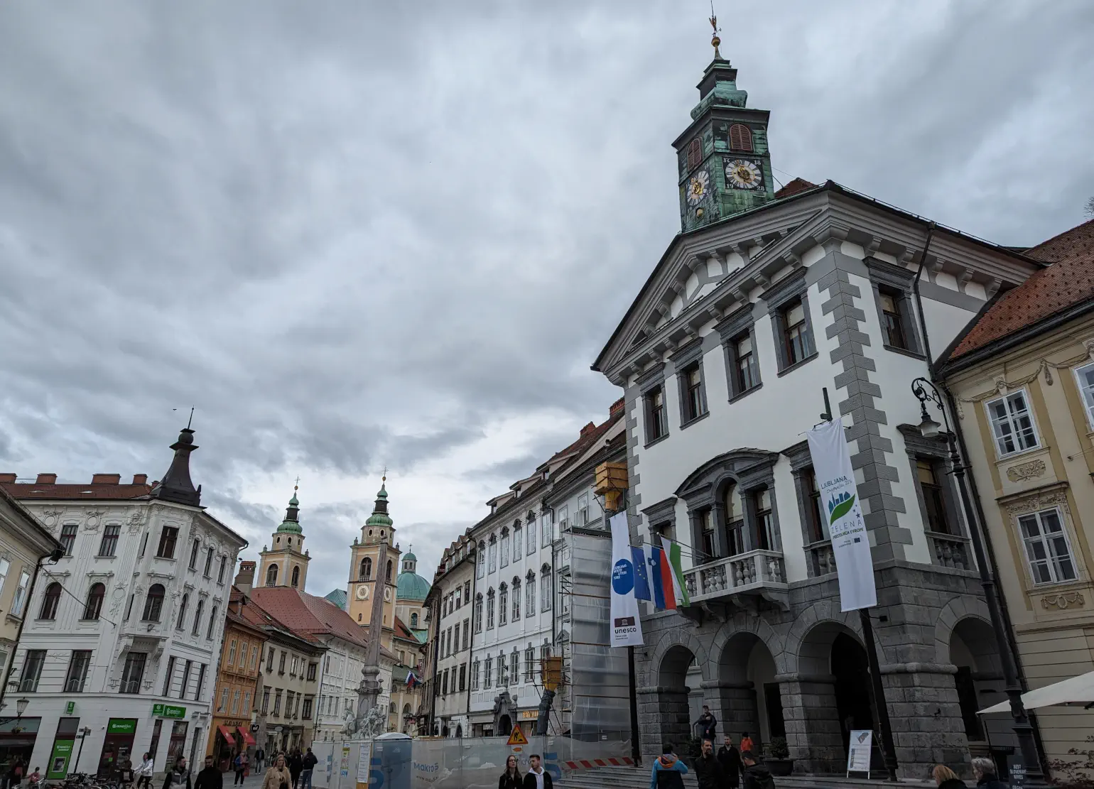 A colorful European city square with clocktower and church