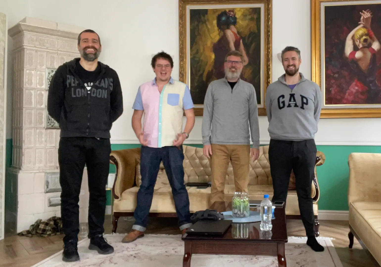 4 men standing in a living room smiling for the camera